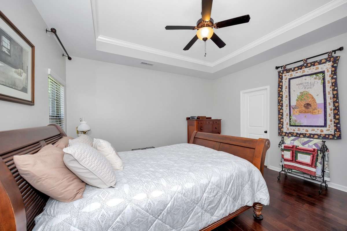 Living Room- wood flooring, trey ceiling, ceiling fan, crown molding