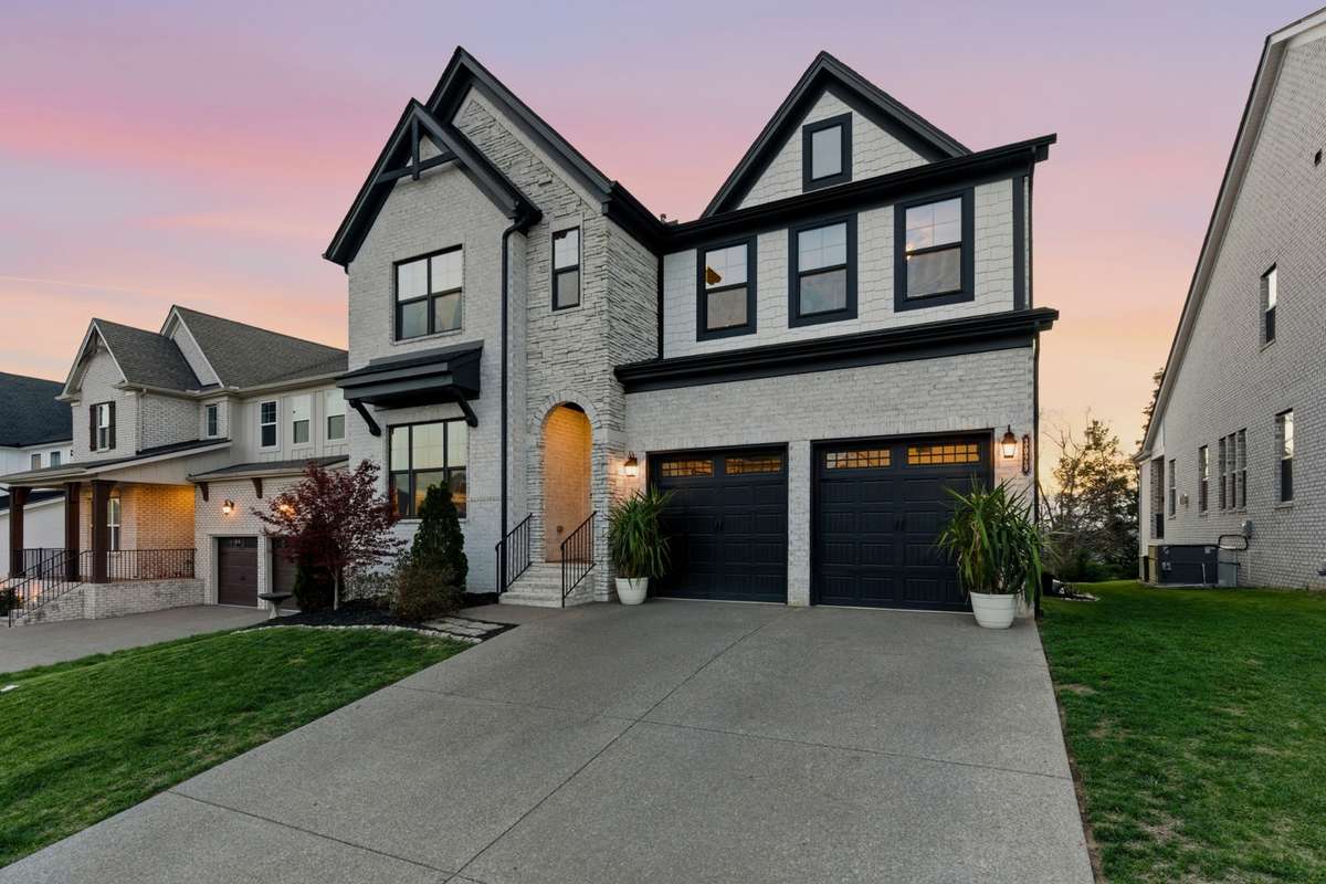 As you walk up, you’re welcomed by a covered entry with an arched opening and warm exterior lighting.