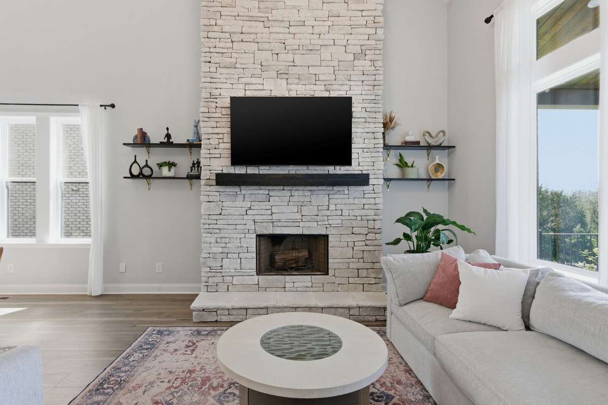 The living room is anchored by a floor-to-ceiling wood burning stone fireplace that draws your eye the second you walk in.