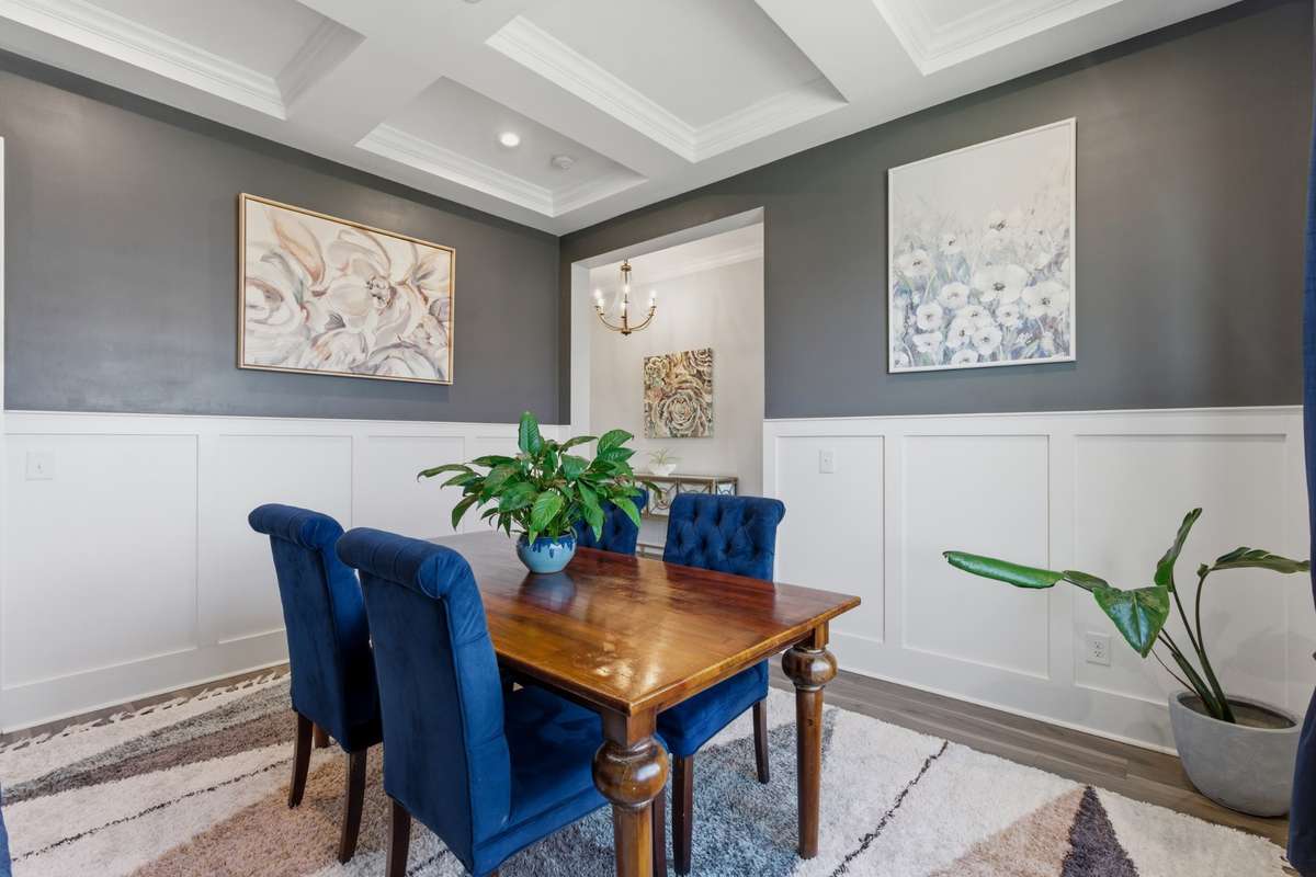 Coffered ceilings, detailed trim work, and natural light from the front window make this a standout space for hosting and gatherings.