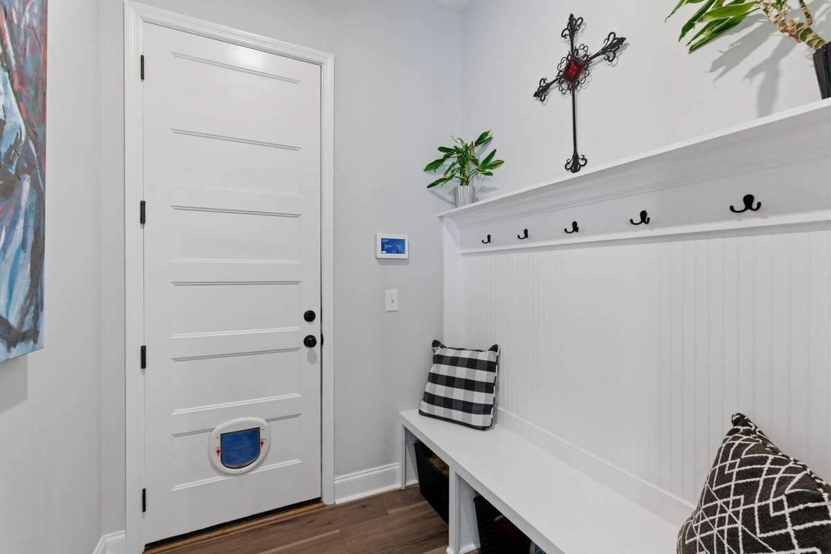 This mudroom right off the entry is such a practical touch, with built-in seating and hooks to drop everything when you walk in.