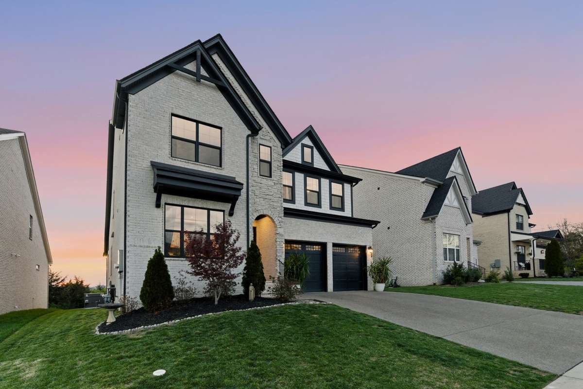 As you walk up, you’re welcomed by a covered entry with an arched opening and warm exterior lighting.