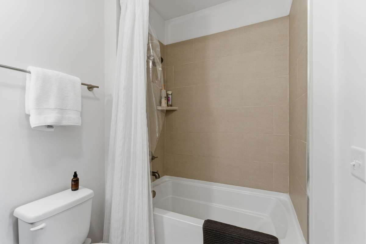 The bathroom features another shower/bathtub combo, offering flexibility and convenience for guests.
