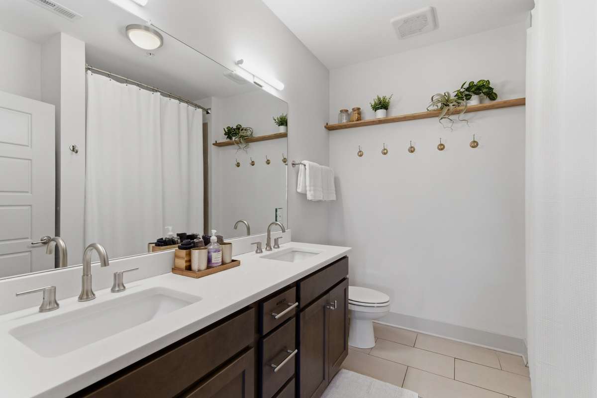 The attached bath features quartz double vanities and an extra-wide mirror that makes getting ready easy.