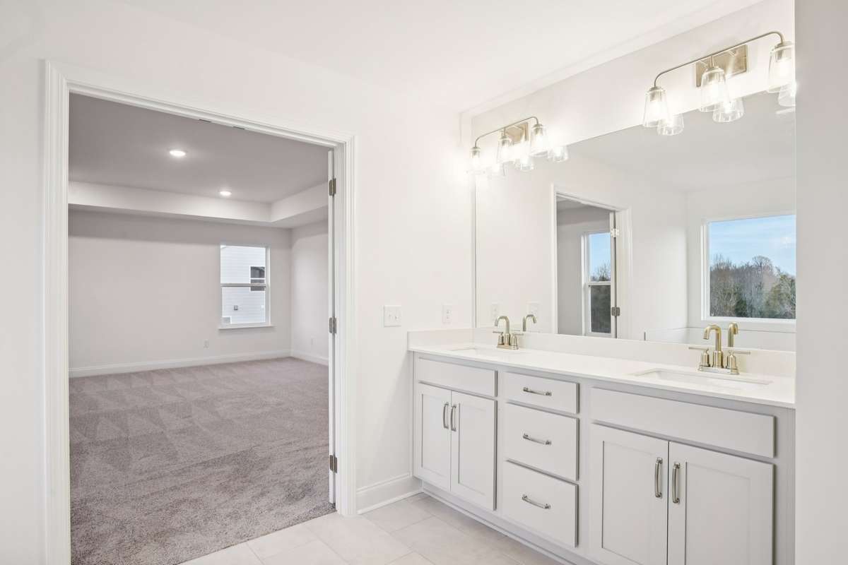 Dual sinks set in elegant quartz countertops offer both style and functionality in the primary bathroom-providing ample space for busy mornings.