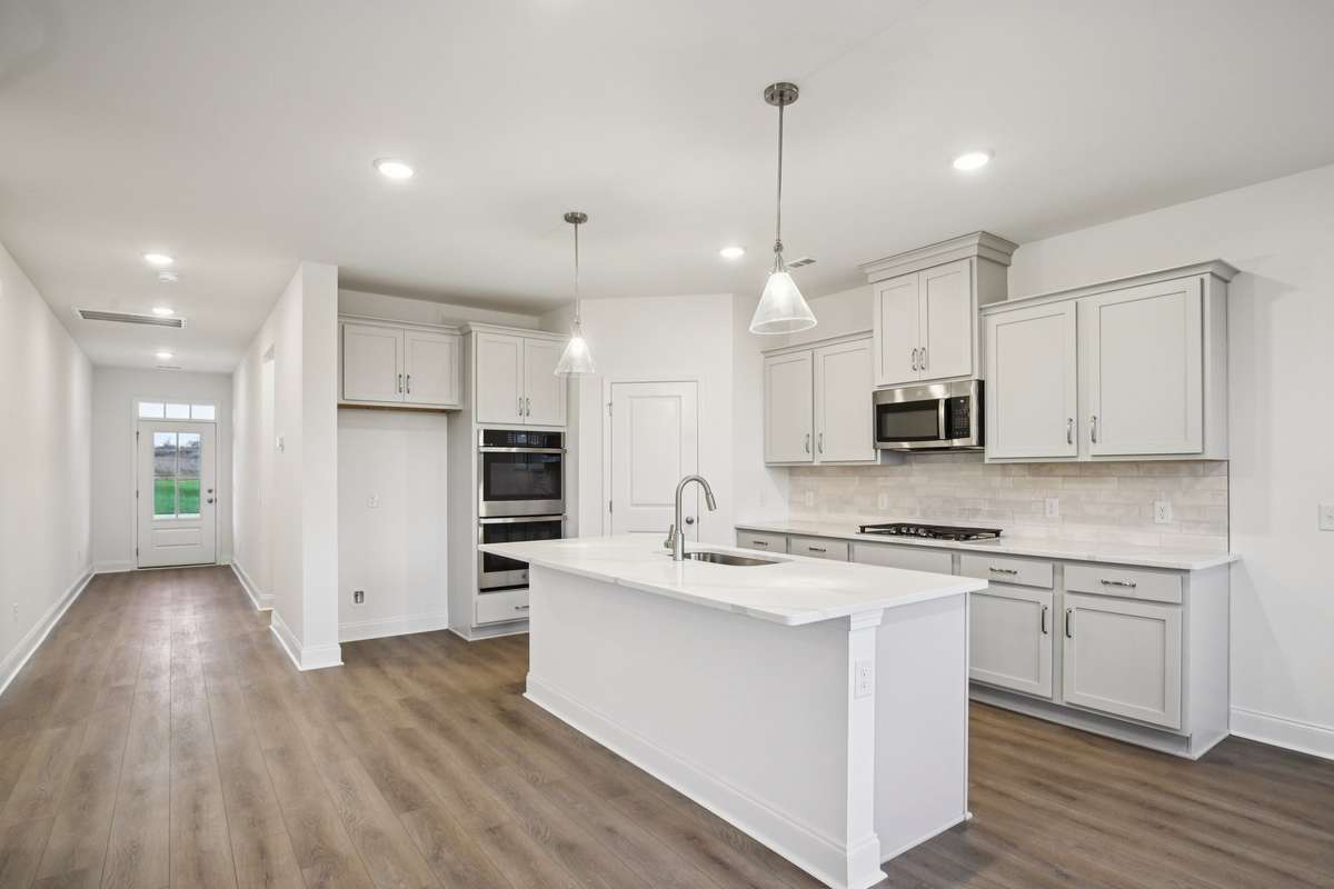 Enjoy cooking in your beautiful gourmet kitchen that features gray cabinetry, quartz countertops and a 3" x 12" subway tile backsplash!