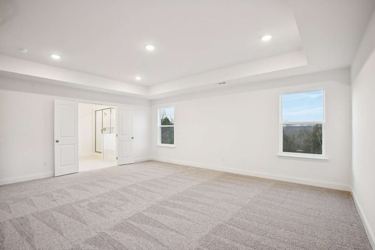 The Primary Bedroom is located on the 2nd floor. A tray ceiling with recessed lighting adds architectural elegance and a warm ambiance, while large windows fill your bedroom with natural light.