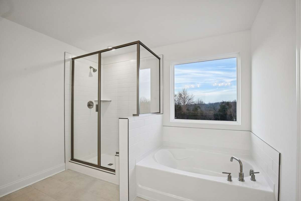Spacious walk-in shower with stylish tile and a built-in seat—perfect for added comfort and everyday convenience in the owner's bath.