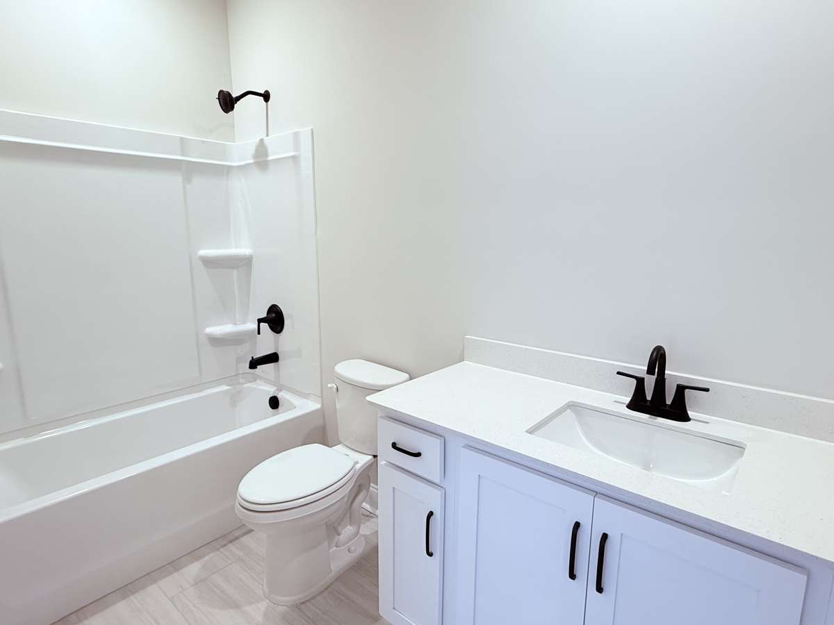 Bath 2 features tile flooring and quartz countertops, combining durability with a modern, clean look.