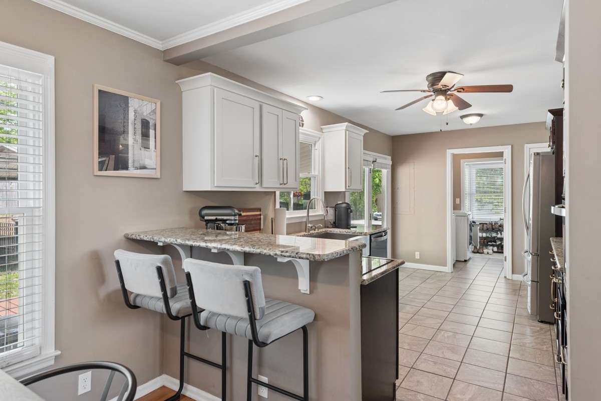 Renovated kitchen with granite counters and tile flooring.