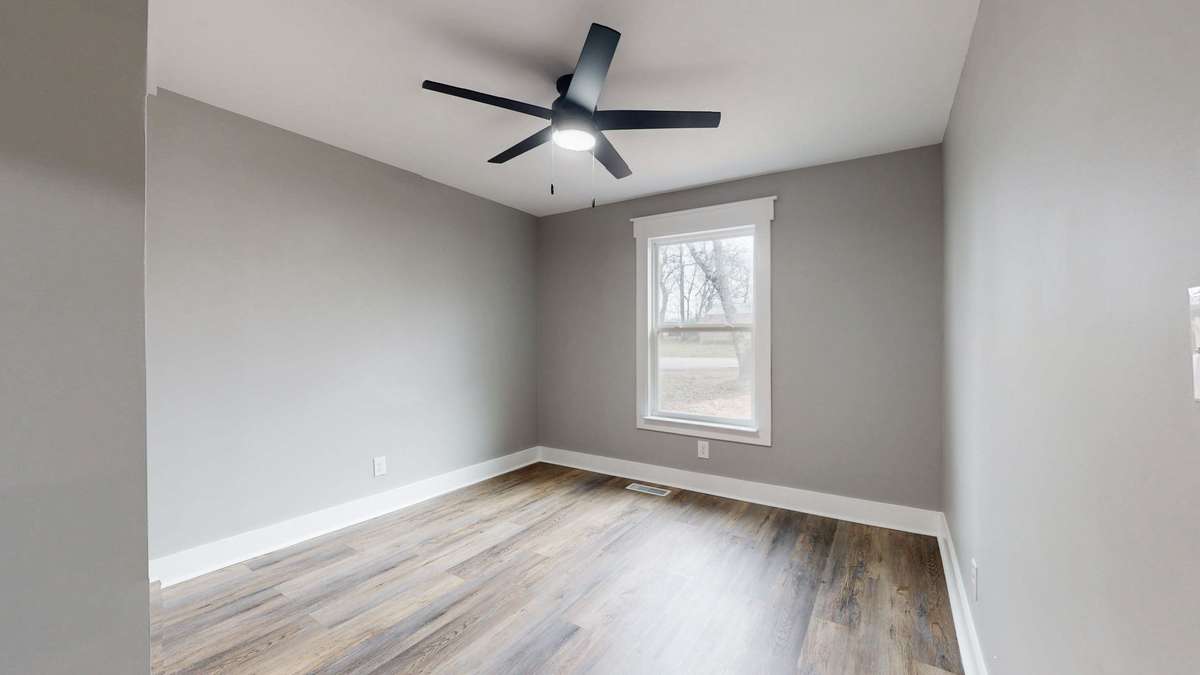 Bedroom 2 with a new ceiling fan and window with upgraded trim package
