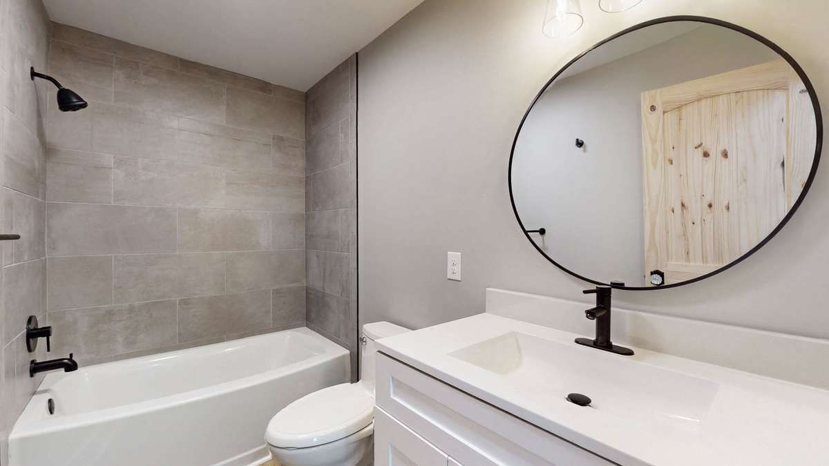 Second bathroom featuring new tub/shower base and tile surround