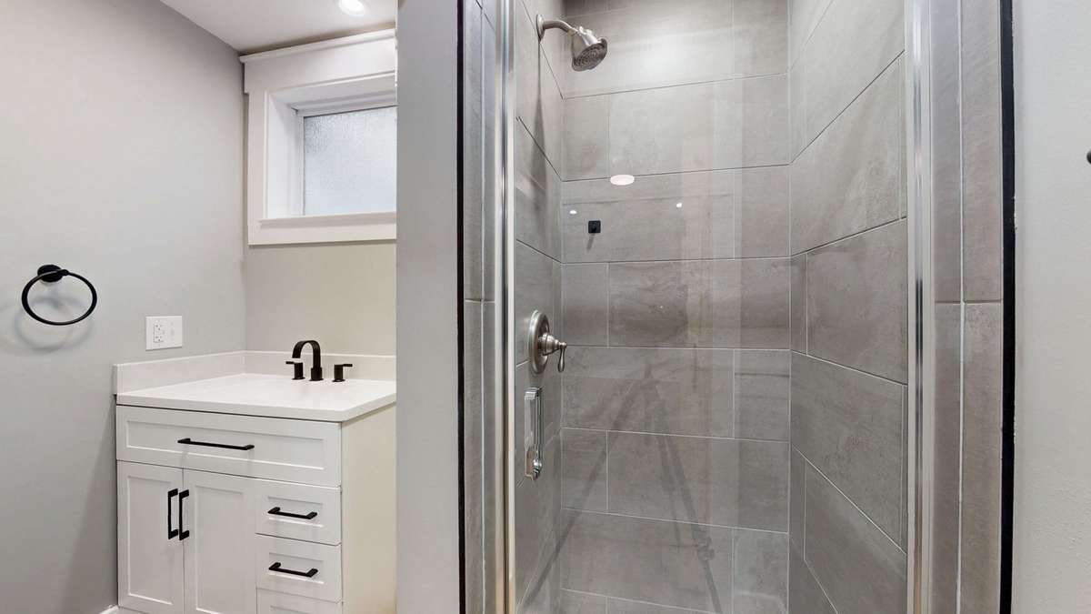 Primary bathroom with tile shower, vanity, upgraded toilet, and nice oversized frosted window