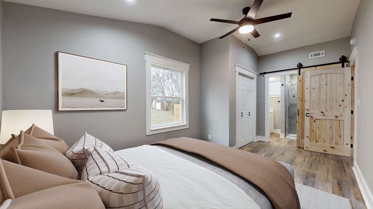 Primary bedroom virtually staged. High ceiling, nice size closet, and a full bathroom.