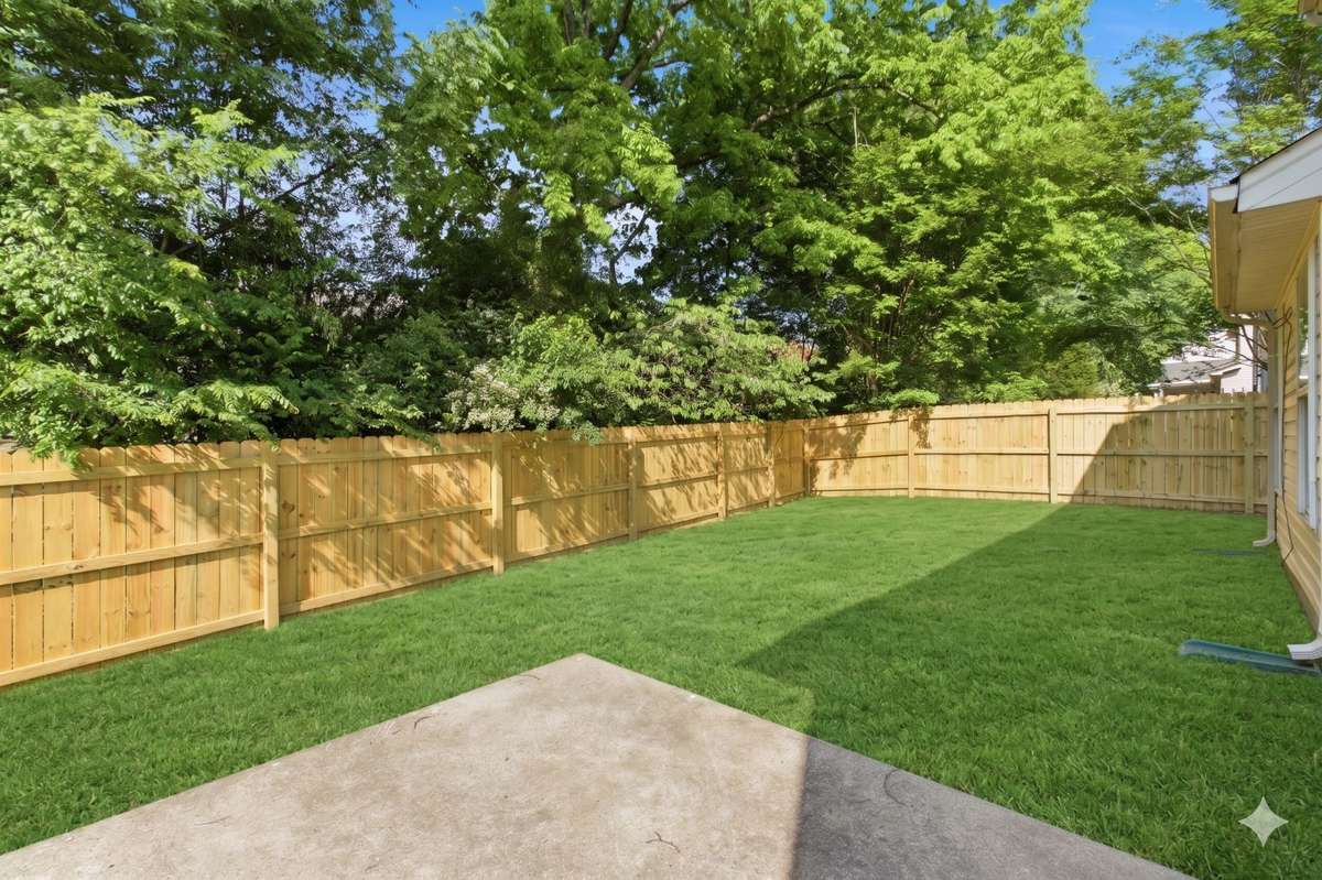 Brand new wooden privacy fence enclosing the lush, green backyard space
