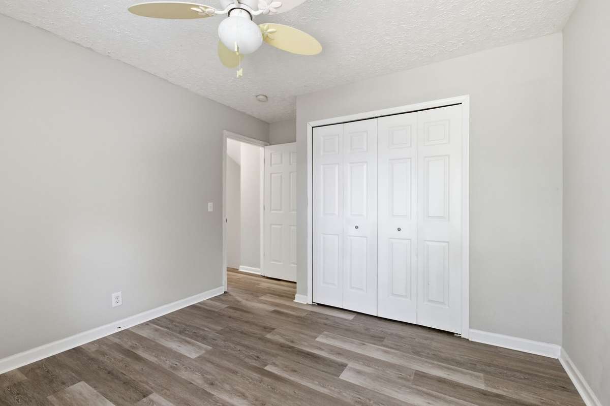 Generously sized secondary bedroom featuring a ceiling fan, large window, and new LVP flooring.