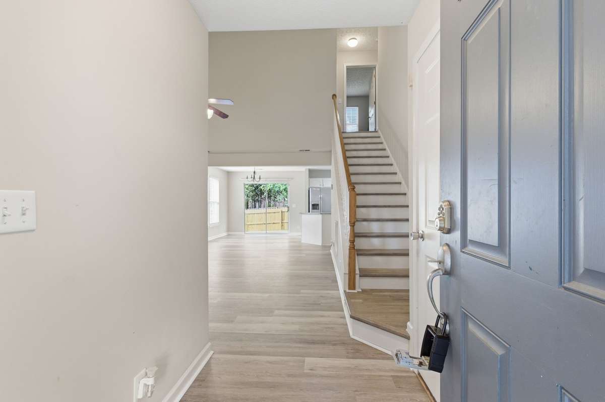 Bright entryway with brand new LVP flooring opening into the main living space.