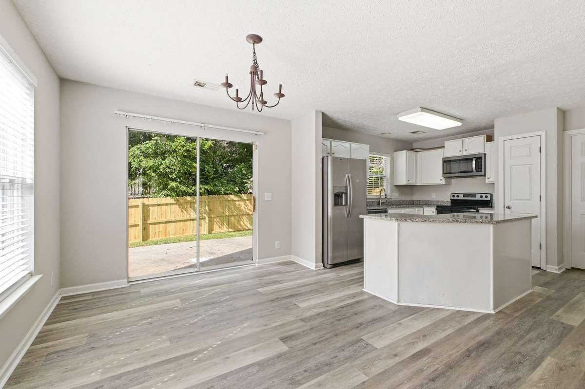 Eat-in dining space with a classic chandelier and sliding glass doors leading to the patio