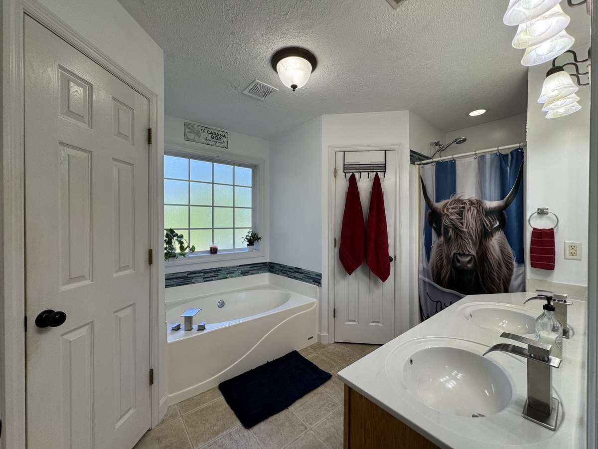 Primary Bathroom boasts double sinks, a soaking garden tub, and a seperate shower.