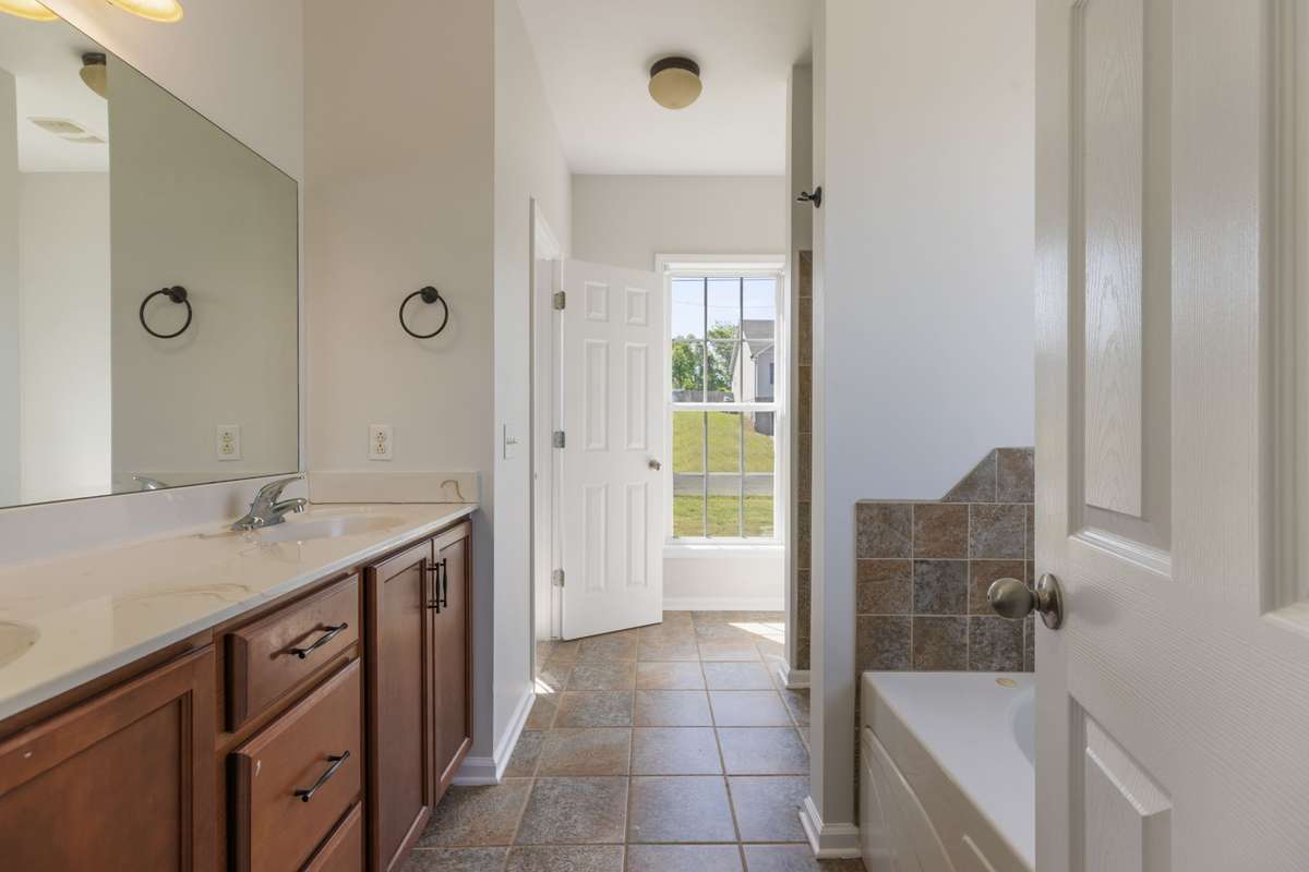 Ensuite bathroom with double vanity, garden tub, stand up shower, and large closet!