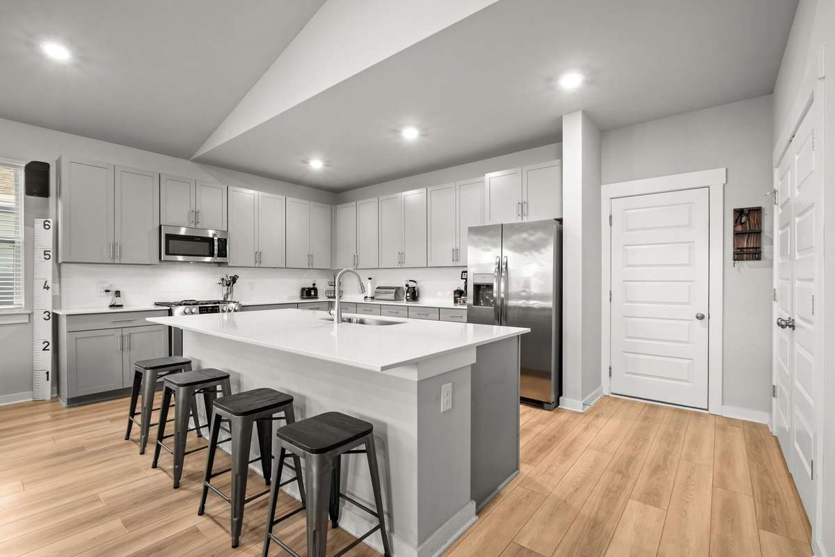 The island is a perfect spot for a snack or to catch up on the day's emails and texts. The pantry in on the right is this photo. The door leads into the 2-car garage.