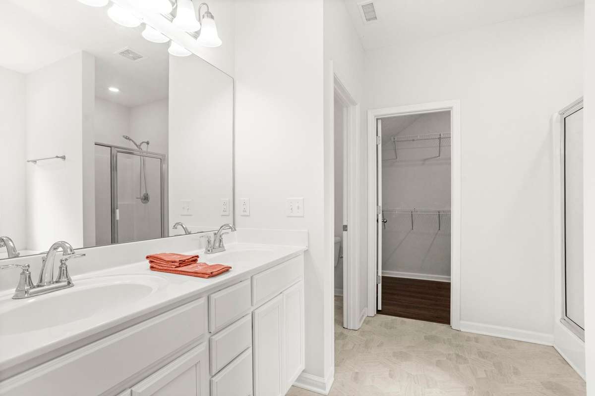 Double vanities in primary bathroom with large walk in closet
