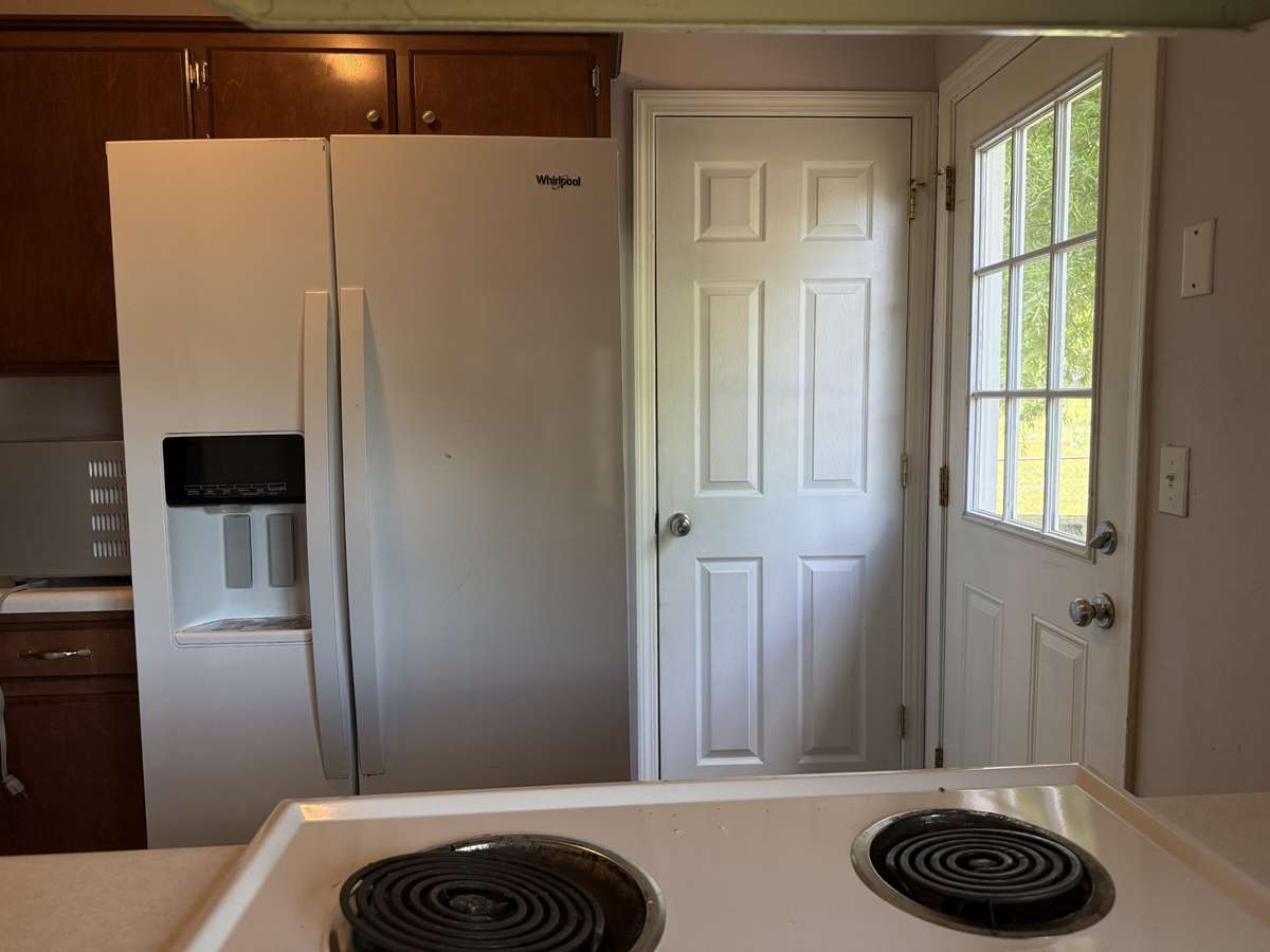 Refrigerator remains.  Door beside refrigerator provides access to pantry.
