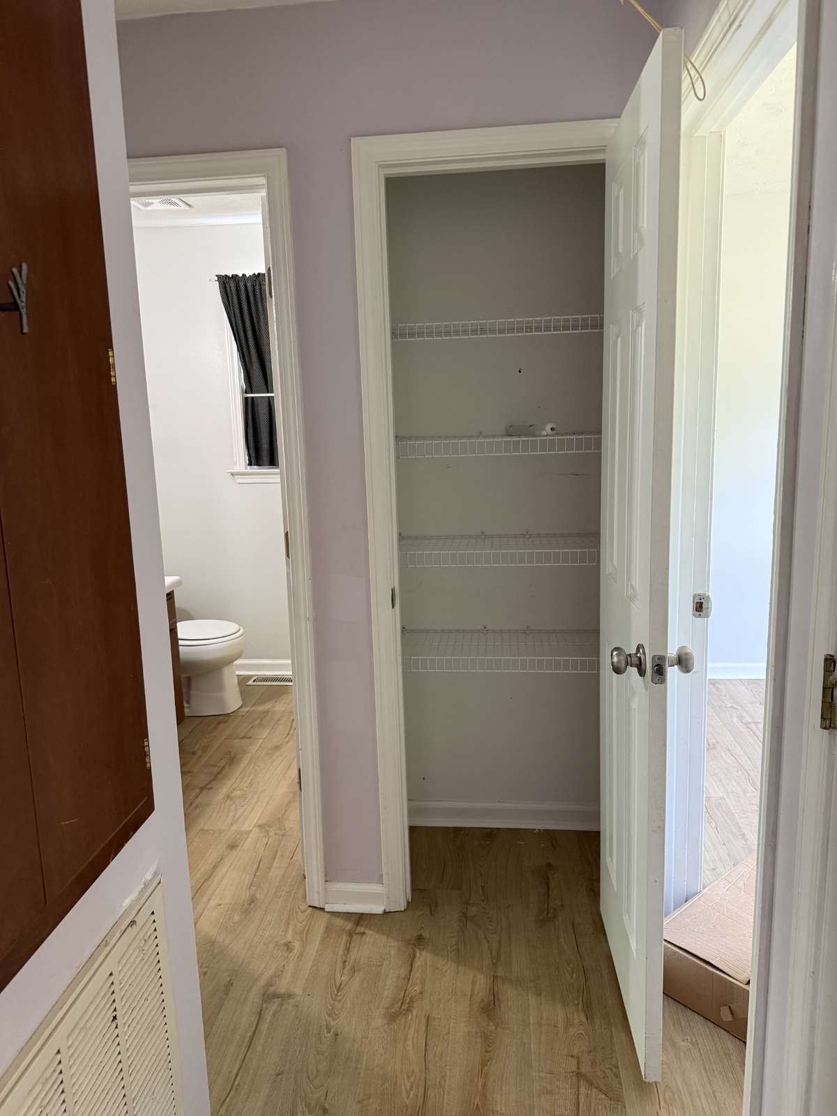 Hallway off living room leading to additional bedrooms and full bath also features two closets.  Here's the linen closet.