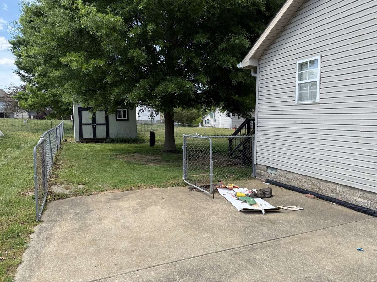 Double gate at end of driveway leads to fenced back yard.