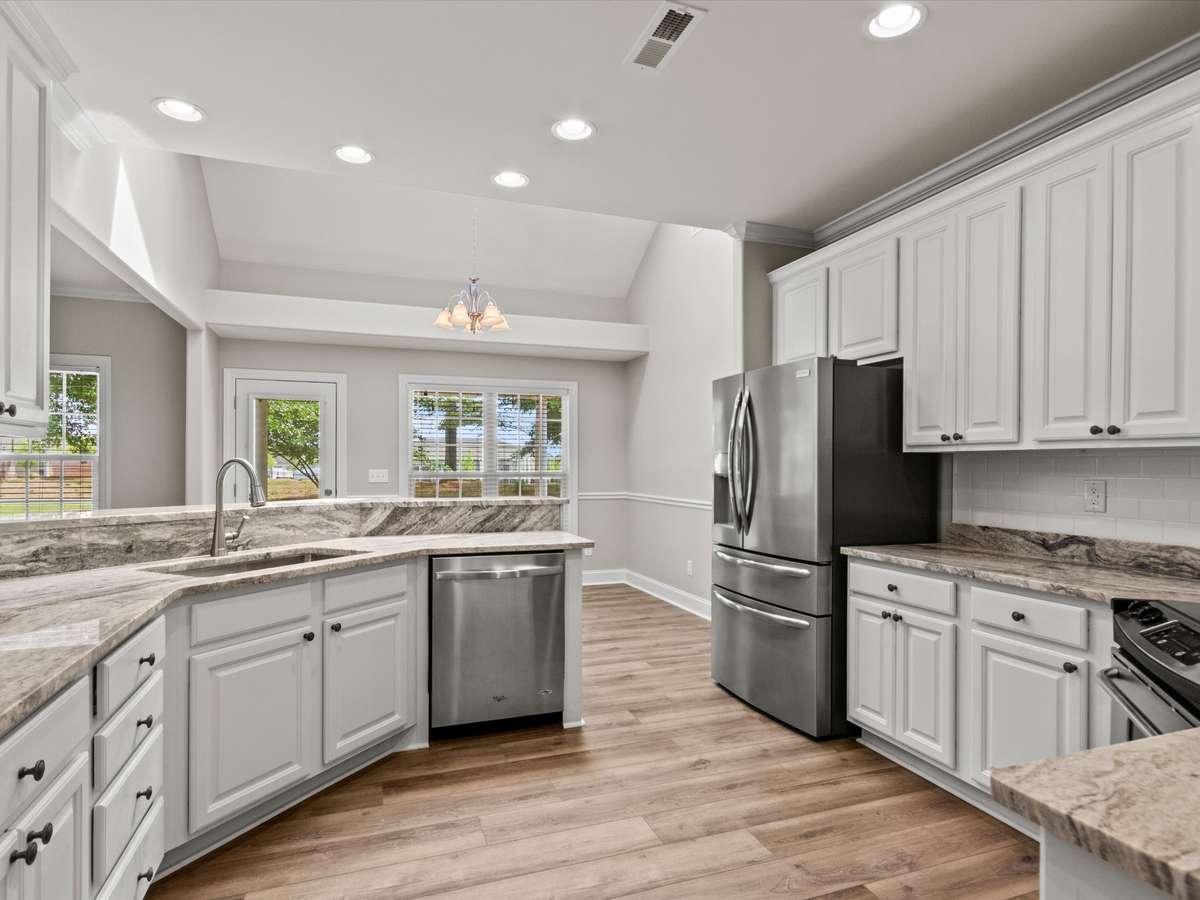 Ktichen- LVP flooring, crown molding recessed lighting, granite countertop, eat in kitchen, pantry, stainless steel appliances