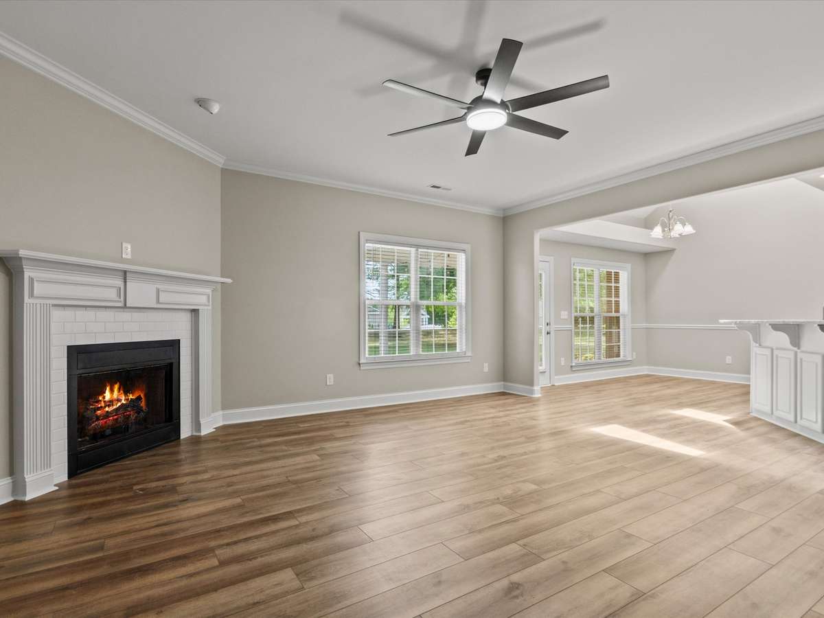 Living Room- LVP flooring, ceiling fan, crown molding, 9' ceiling, fireplace