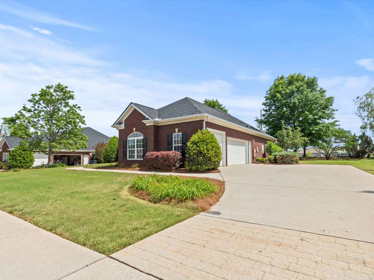 Front of house - Full brick, concrete driveway and sidewalk, beautiful landscaping, covered front entry