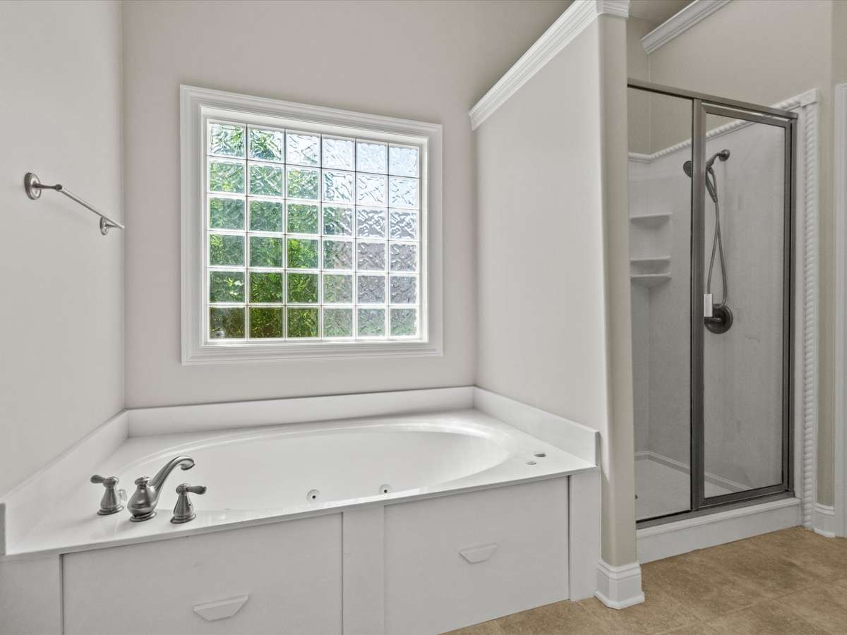 Primary Bathroom - tile flooring, vaulted ceiling, double vanities, walk in closet, skylight, separate whirlpool tub and shower