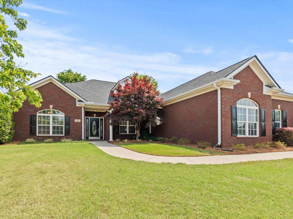 Front of house - Full brick, concrete driveway and sidewalk, beautiful landscaping, covered front entry