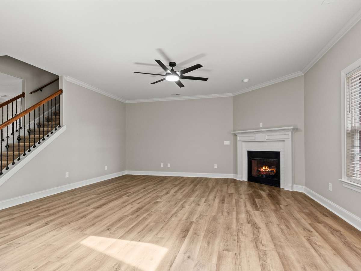 Living Room- LVP flooring, ceiling fan, crown molding, 9' ceiling, fireplace