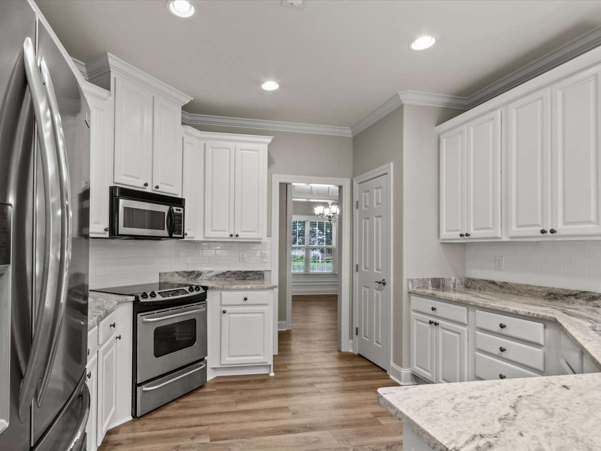 Kitchen- LVP flooring, crown molding recessed lighting, granite countertop, eat in kitchen, pantry, stainless steel appliances