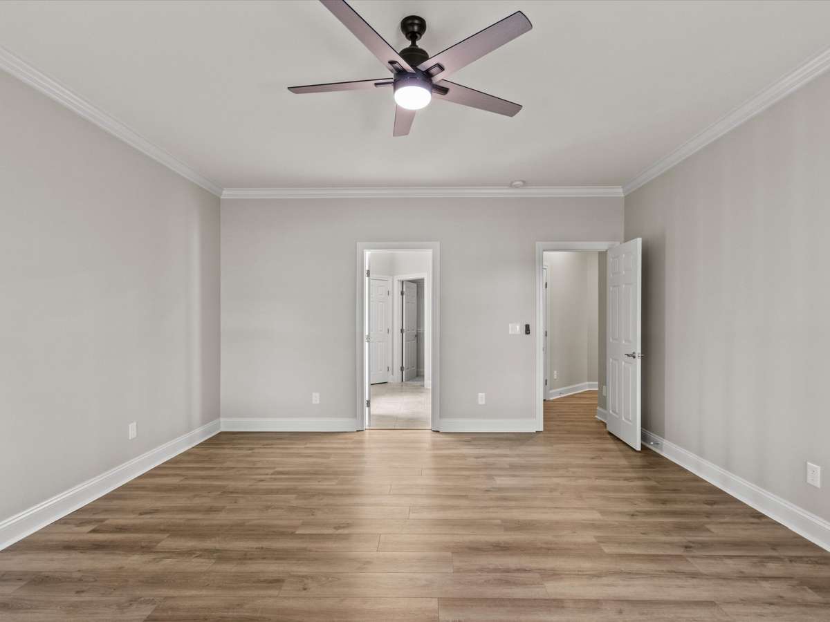Bedroom - LVP flooring, crown molding, ceiling fan
