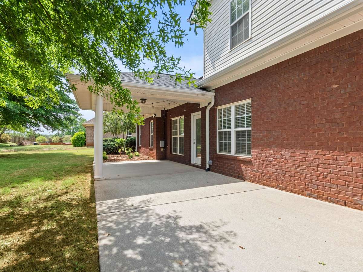 Back of house- Patio, covered patio with house entry, beautiful landscaping
