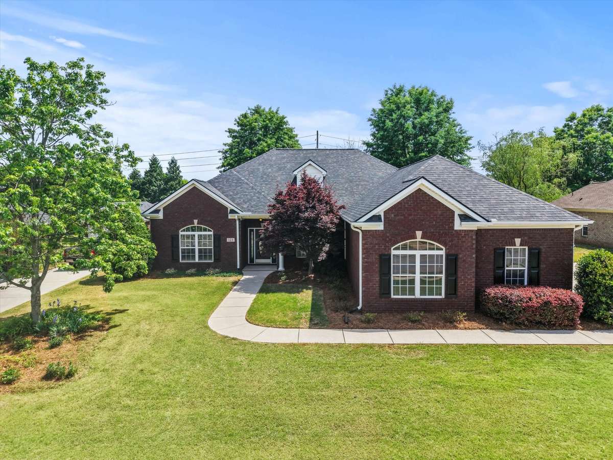 Front of house- Full brick, concrete driveway and sidewalk, beautiful landscaping, covered front entry