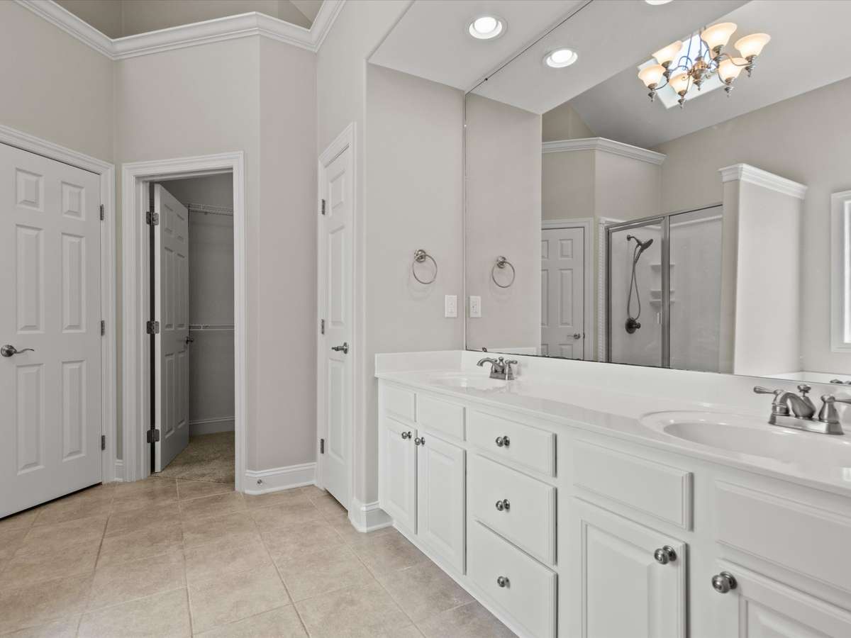 Primary Bathroom - tile flooring, vaulted ceiling, double vanities, walk in closet, skylight, separate whirlpool tub and shower