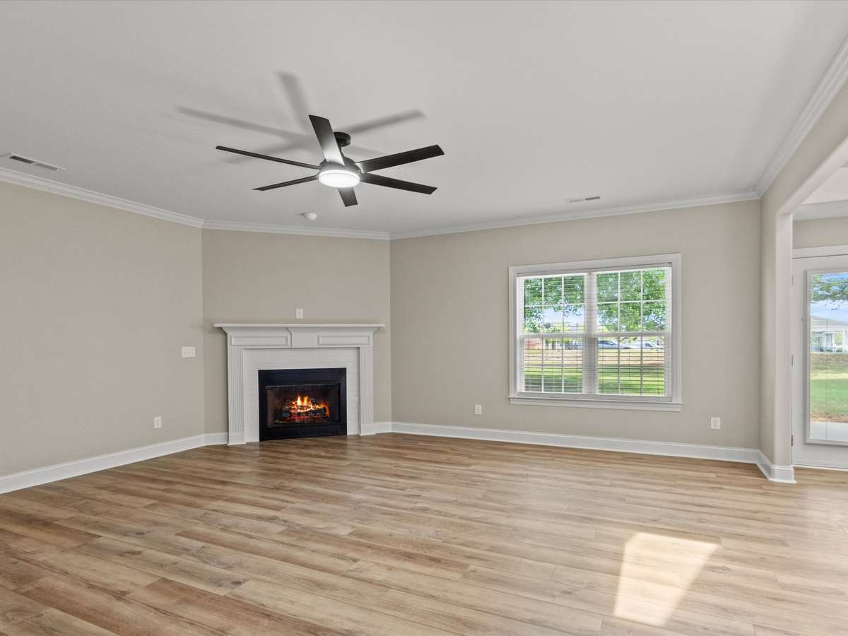 Living Room- LVP flooring, ceiling fan, crown molding, 9' ceiling, fireplace