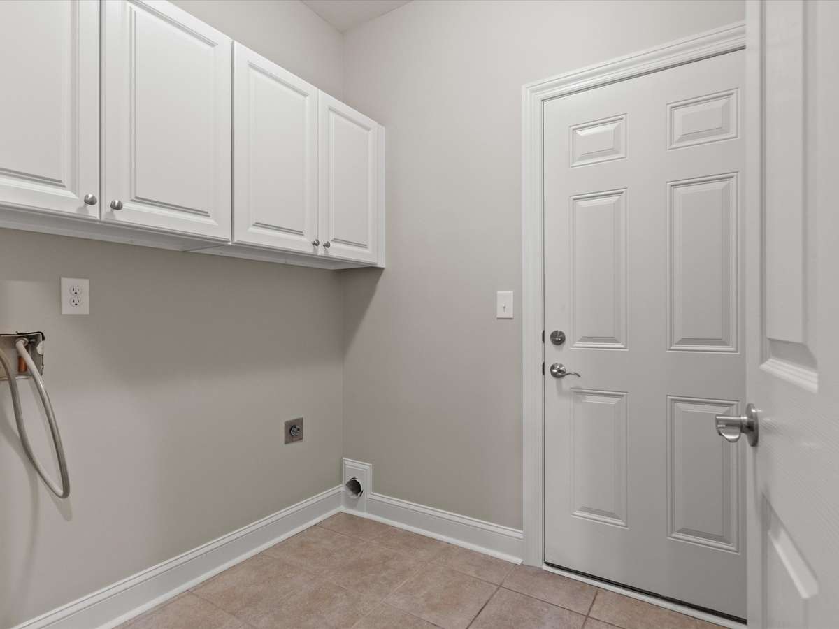 Laundry Room- tile flooring, washer/dryer connections, wood cabinetry