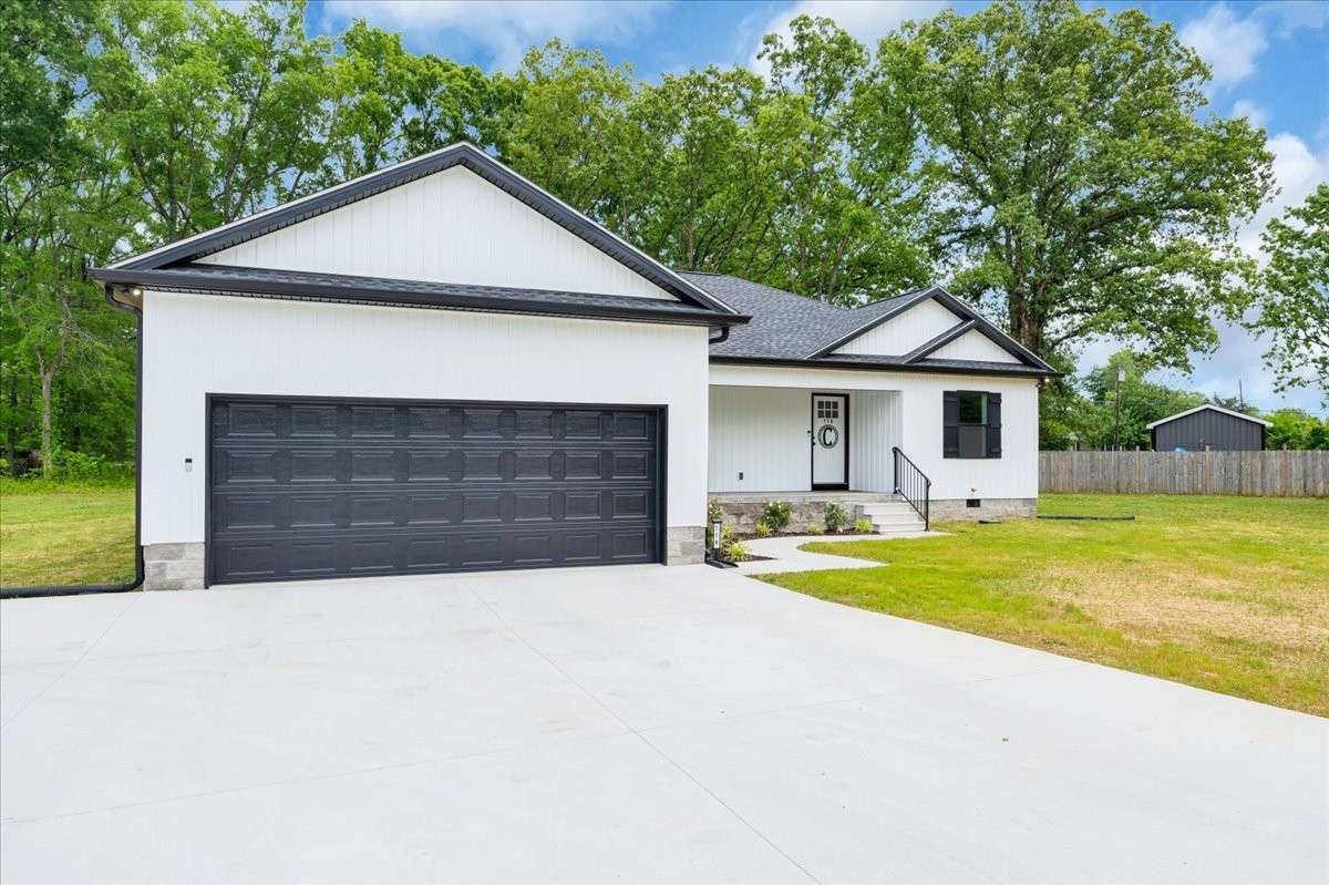 An extra-wide concrete driveway with two  convenient entrances offers ample parking.
