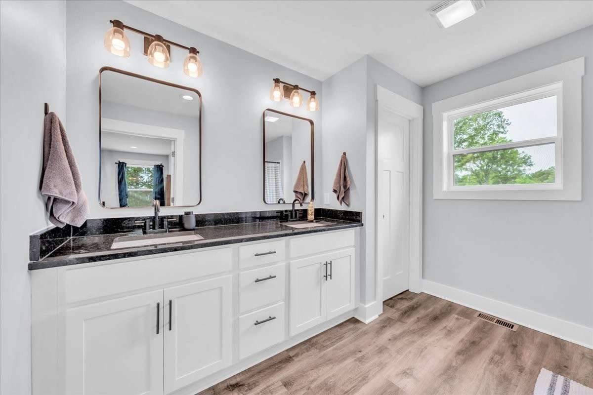 Primary bath with double vanity, granite countertops, water closet and separate shower.