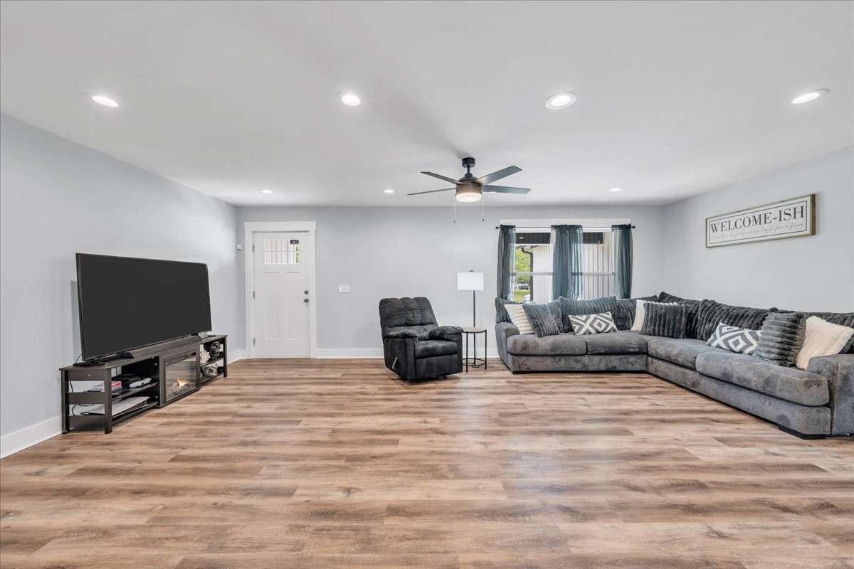 This beautiful great room features recessed lighting that creates a warm, welcoming ambiance, while the modern ceiling fan ensures year-round comfort.