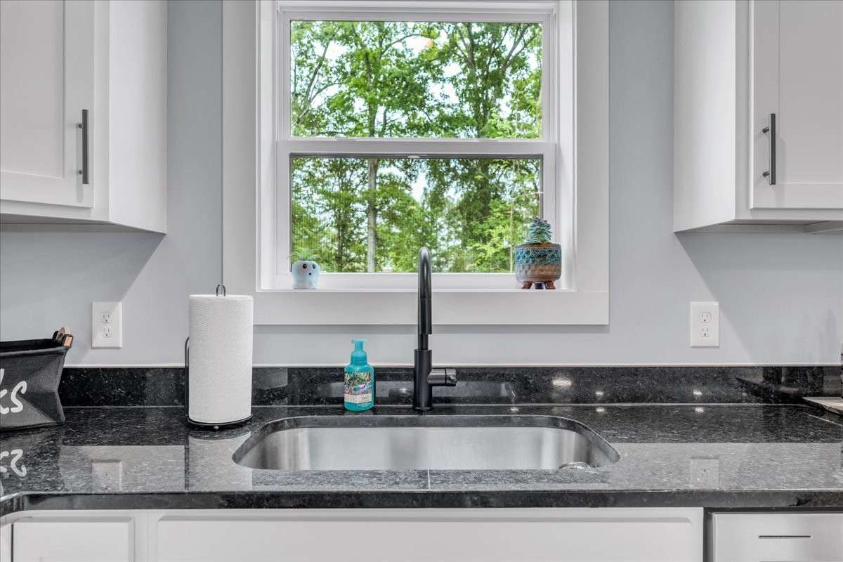 A charming window above the kitchen sink floods the area with natural light, providing a lovely view and creating a cheerful atmosphere.