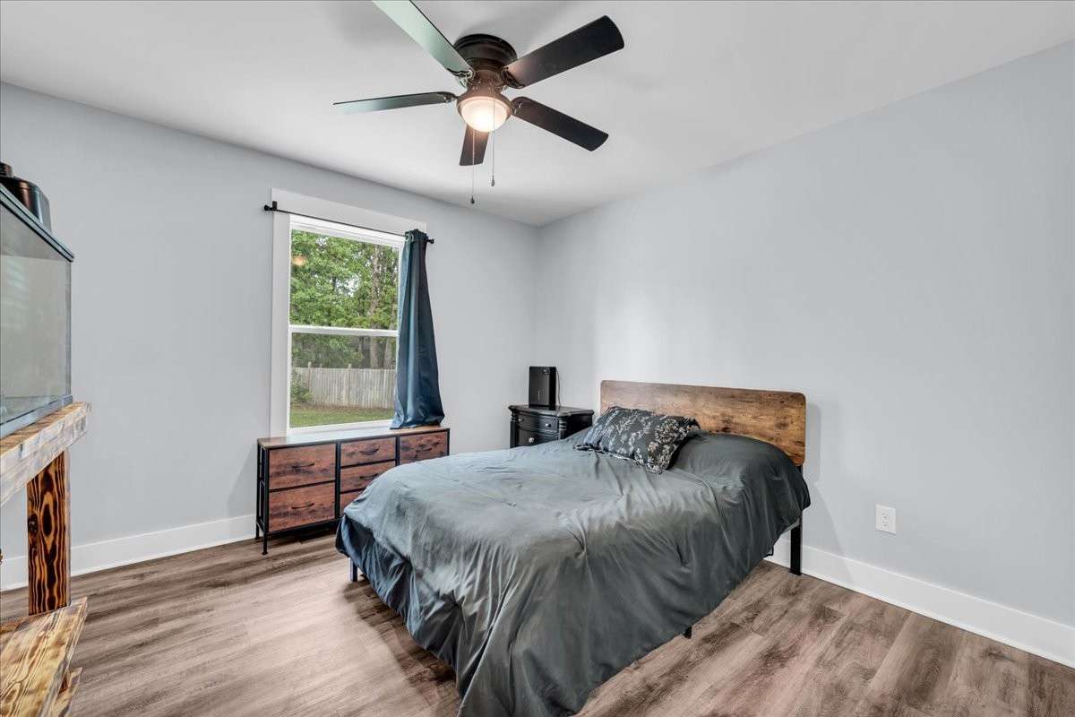 Second bedroom with luxury vinyl flooring, sunny windows, ceiling fan and large closet.