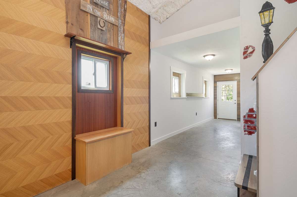 Looking back to the entry foyer / hall from the corner of the large, open living room. The custom window work includes a storage bench that's great for keeping needed items handy.  The stairs on the right lead to the loft that we'll see later.