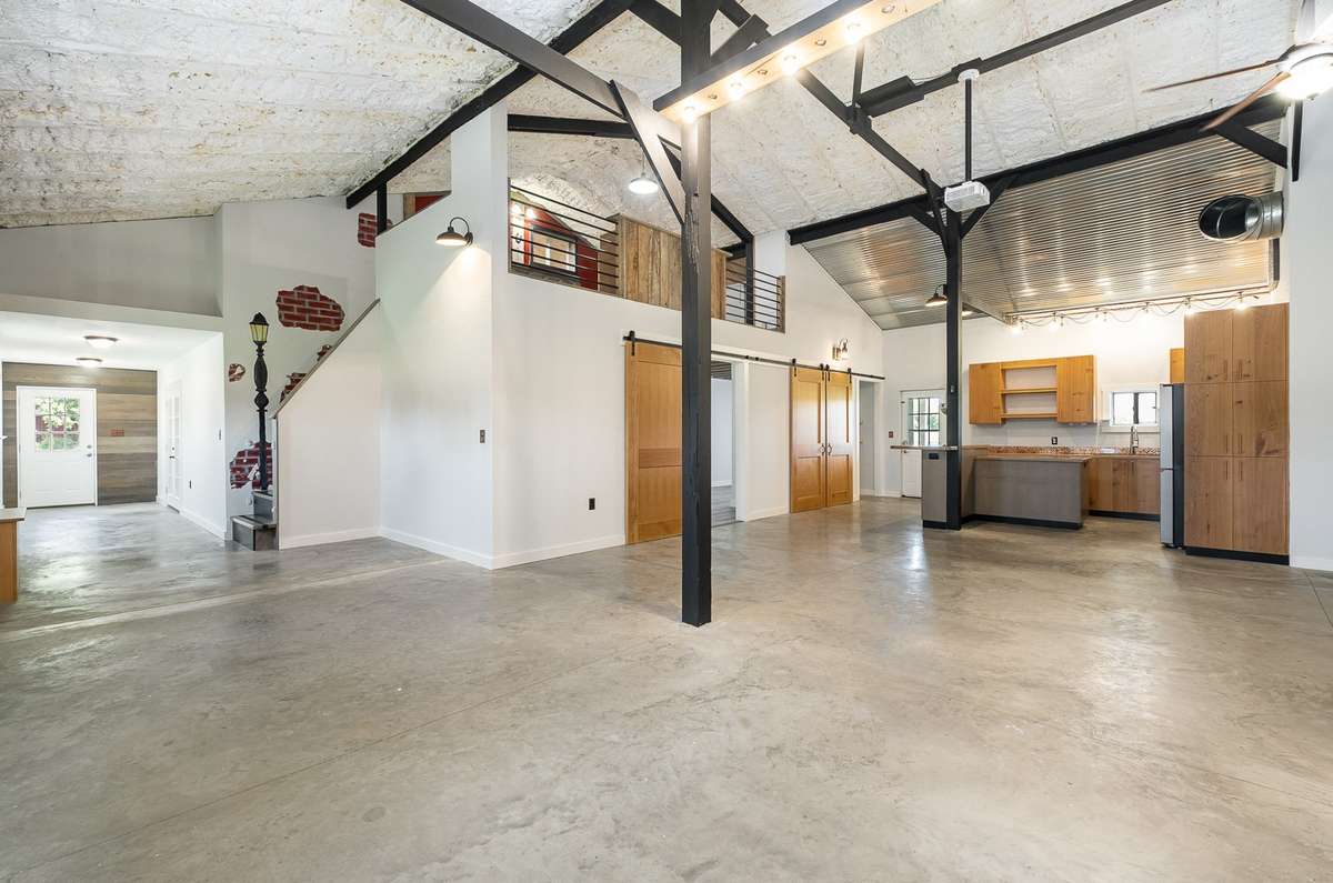 Check out the expansive open concept living area of this truly unique home.  So many possibilities for making it your own personal retreat.  The bedroom is the first barn door in this pic and the loft is above the bedroom.