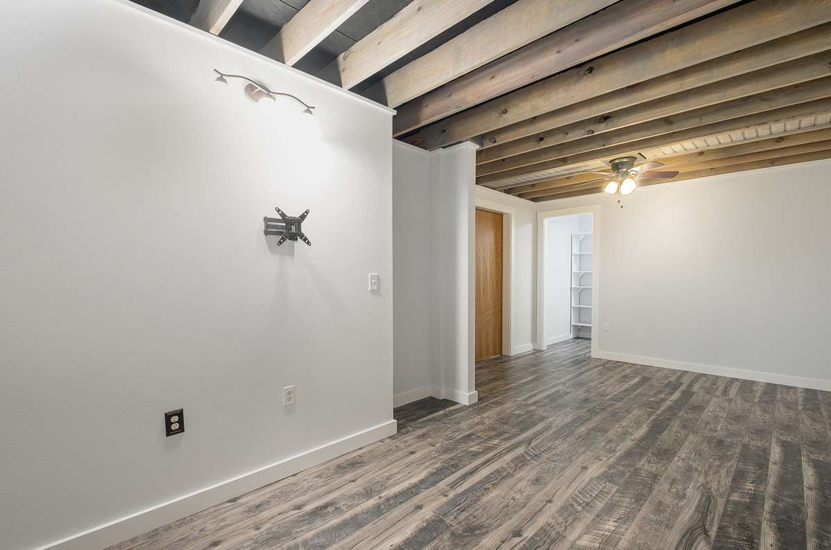 Another view of the bedroom showing how large and versatile the space is. The walk-in closet is the opening just to the right of the brown bedroom door in this pic.